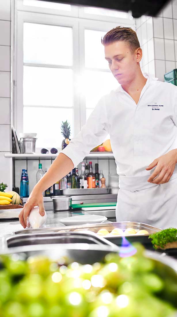 Koch der Max Grundig Klinik beim Zubereiten von Gerichten