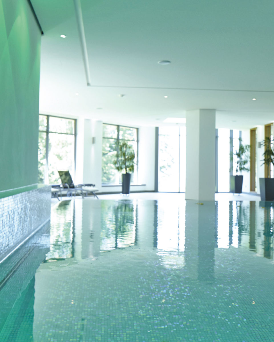 Bewegungsbad der Max Grundig Klinik, Schwimmbecken mit Wasser und Spiegelung der Fenster